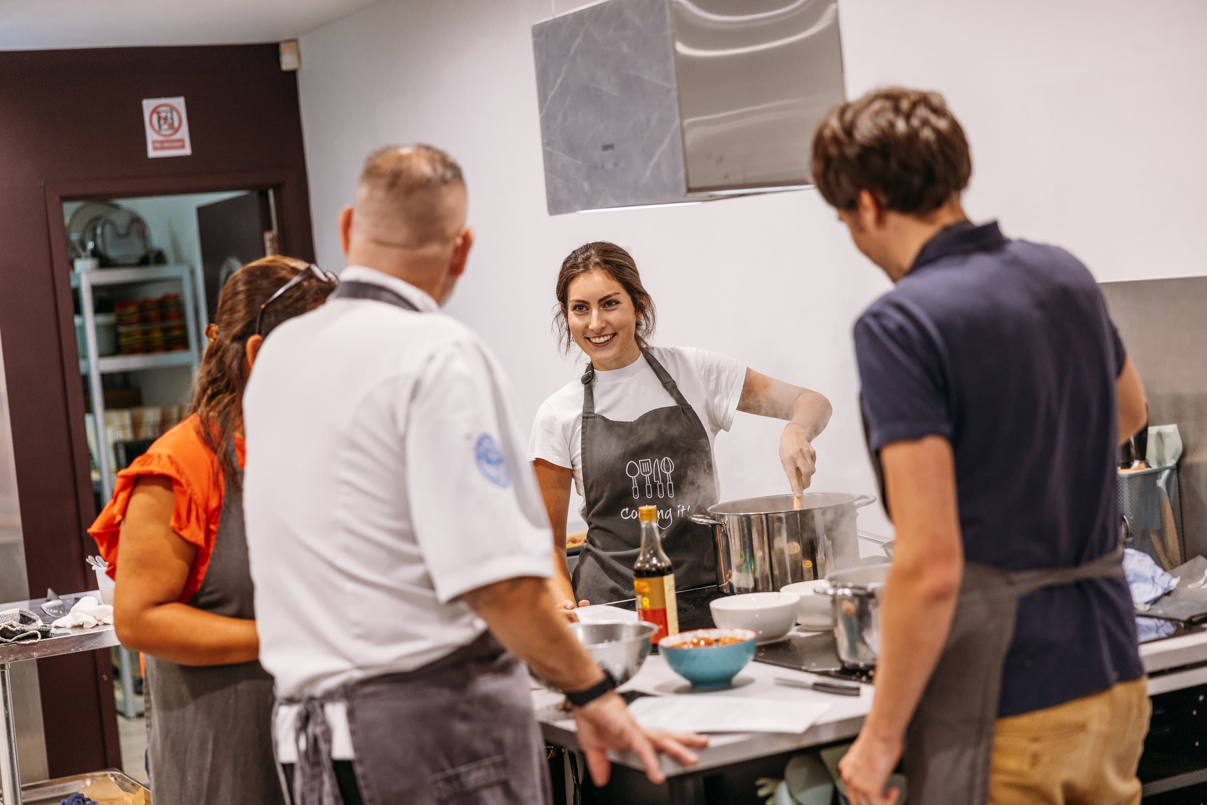 Hands kneading dough on the communal prep table at Cooking It in Bristol